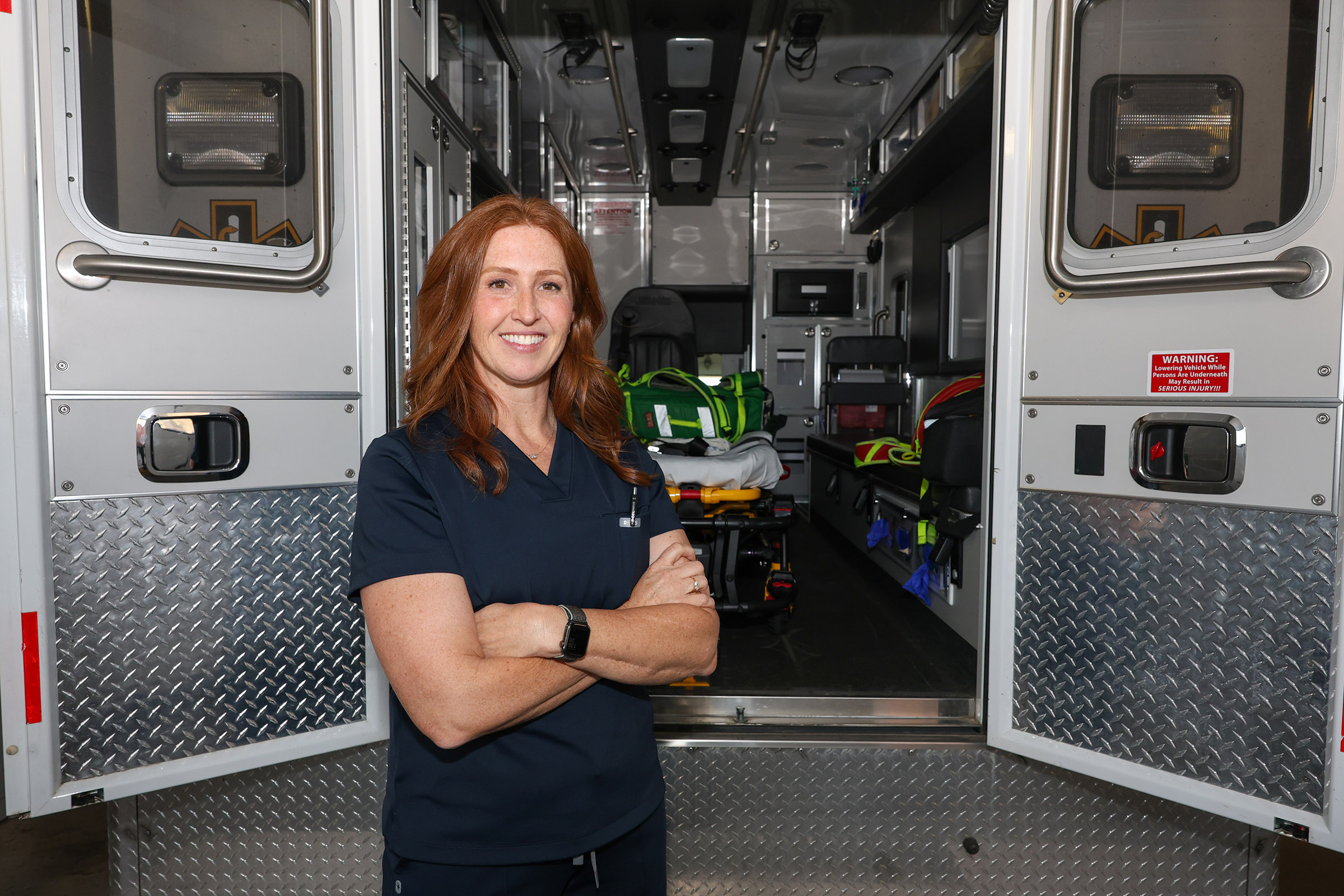 Hilary Miller poses in front of an ambulance