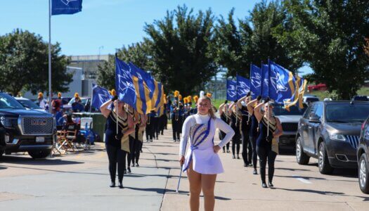 The Pride of the Plains Marching Band performs at the tailgate.