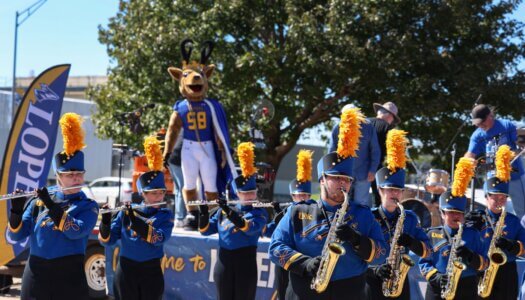 The Pride of the Plains Marching Band performs at the tailgate.