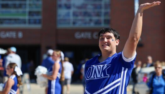 UNK Cheerleader Jacob Morse cheers at the tailgate.