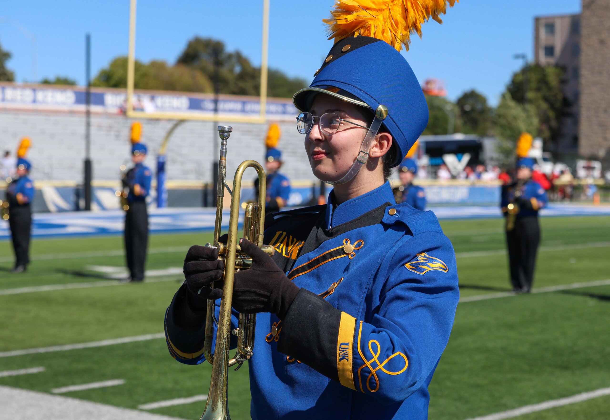 The Pride of the Plains Marching Band performs on the football field.