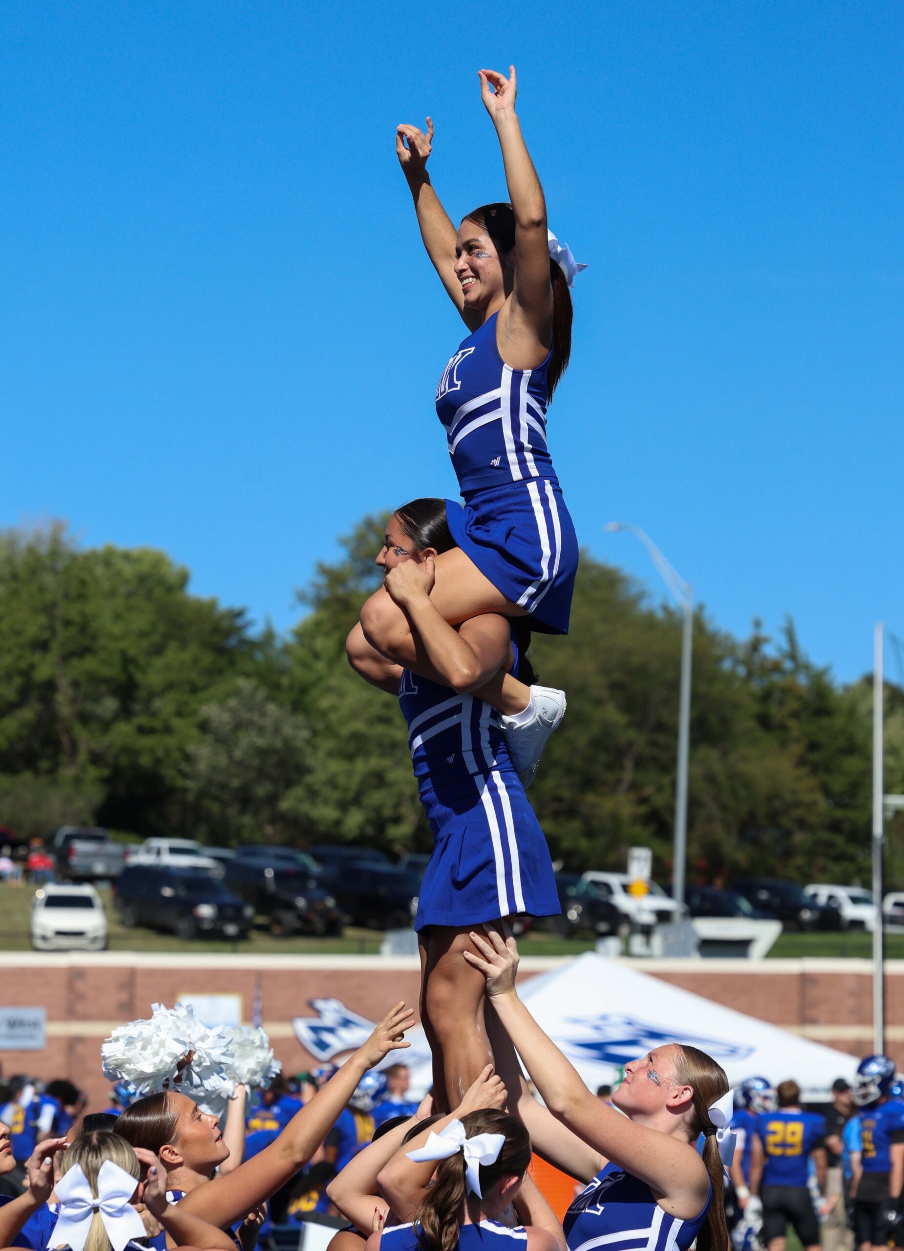 The cheer team does a stunt at the game.
