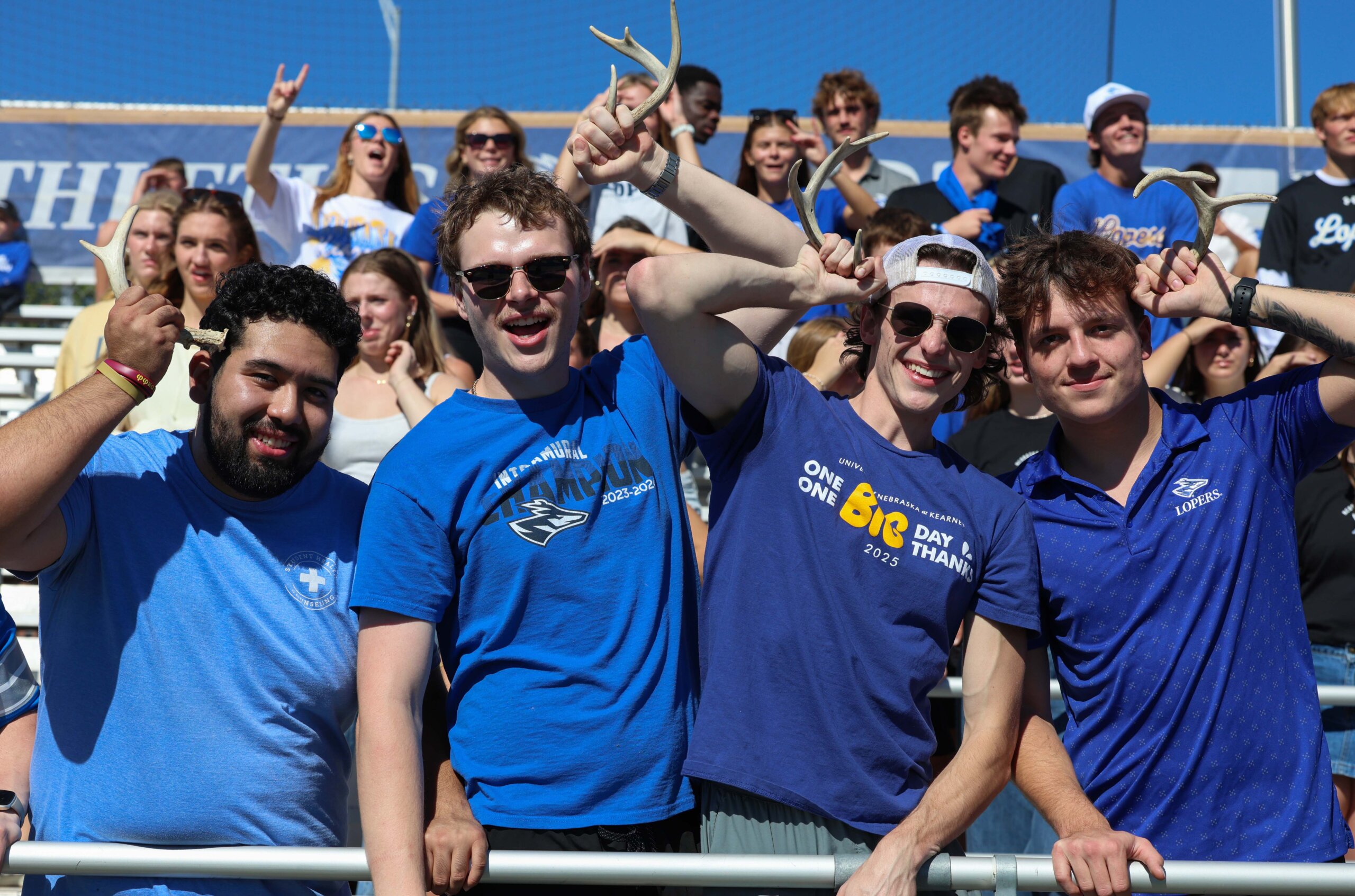 Students hold up antler horns at the football game.