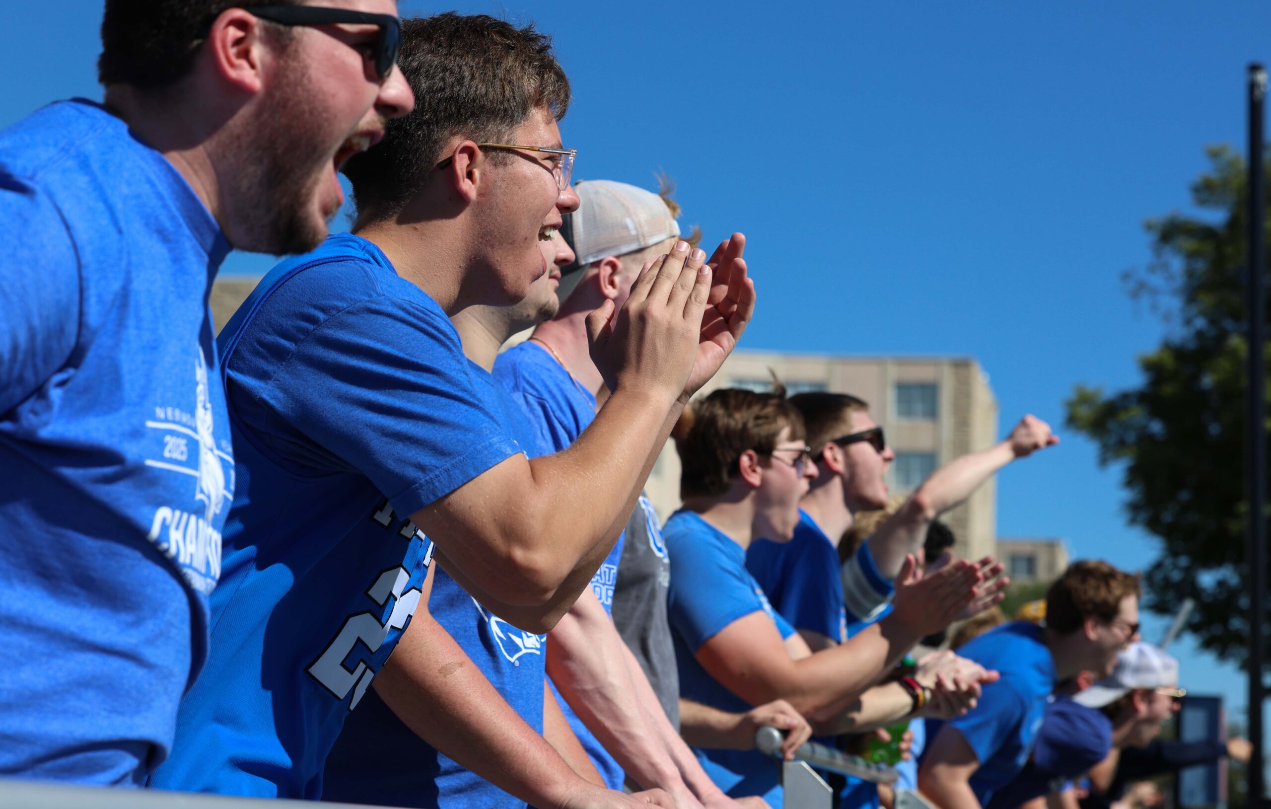 Students cheer from the stands at the football game.