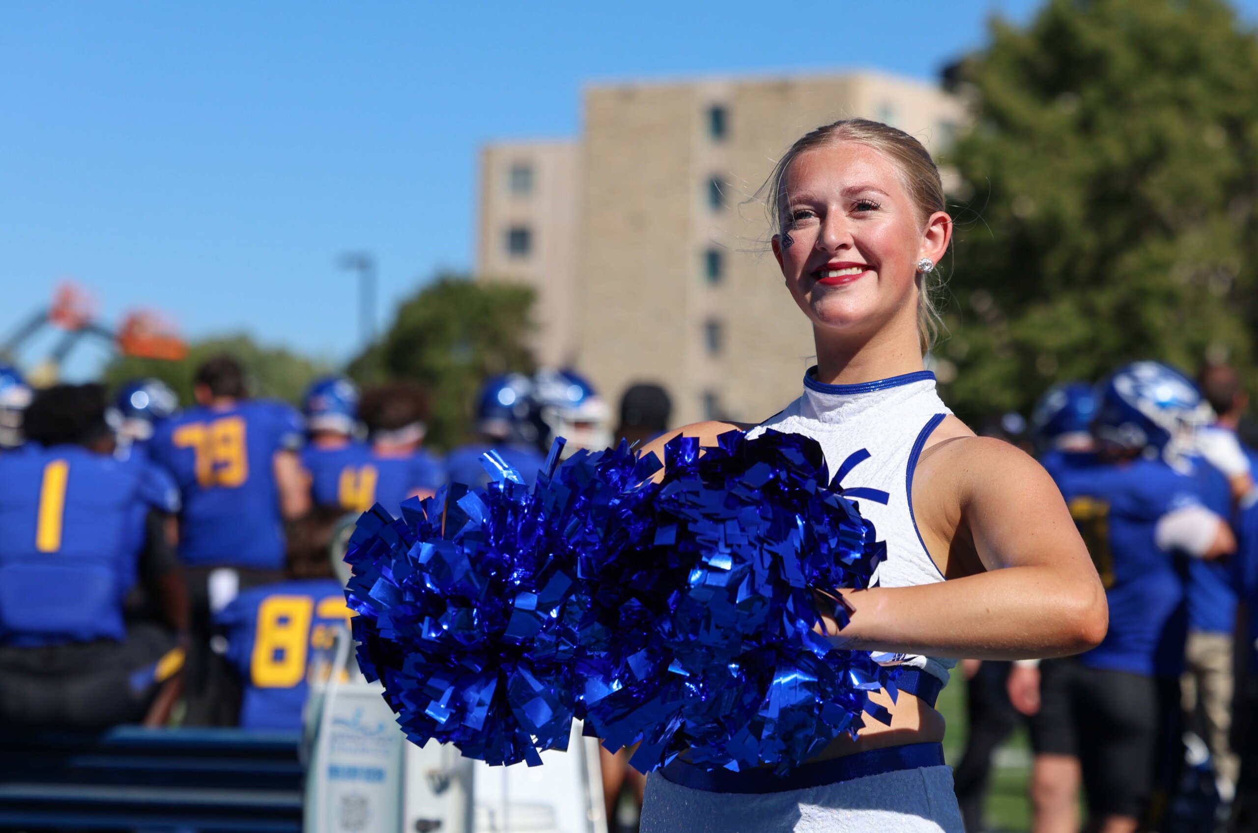 A dancer holds her pom pons.