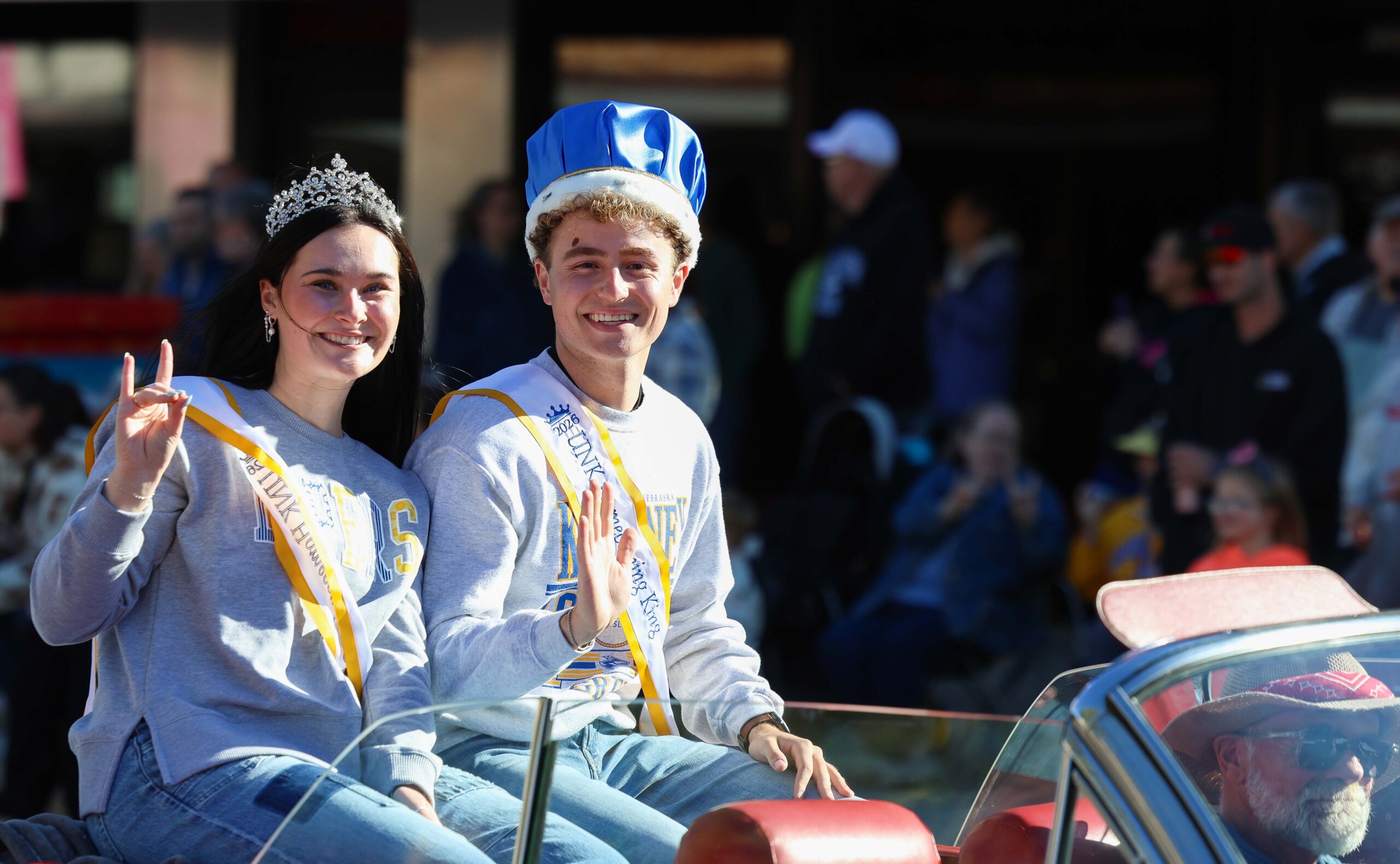 The homecoming queen and king ride in the parade.