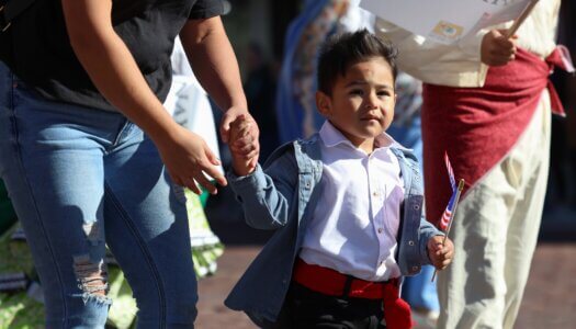 A young boy carrying an American flag walks in the parade.