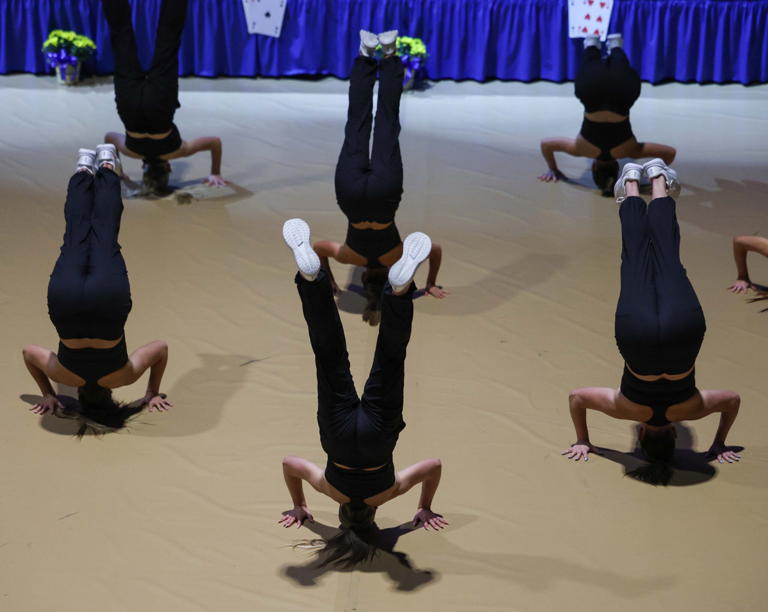 The UNK dance team does a hand stand.