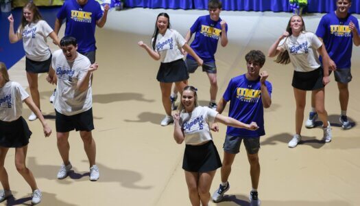 The UNK cheer team performs a routine with UNK wrestlers.